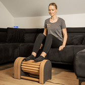 Woman using a foot massager on a couch